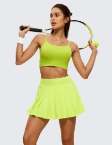 A woman wearing a neon green CRZ YOGA pleated skirt with a snug high-waisted fit, ideal for active sports like pickleball and tennis.