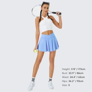 A woman wearing a light blue FireSwan pleated tennis skirt, featuring built-in shorts and a secure pocket for carrying essentials.