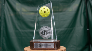 A photo of an epic pickleball trophy. The trophy is made of glass and has a clear tower with a pickleball on top.